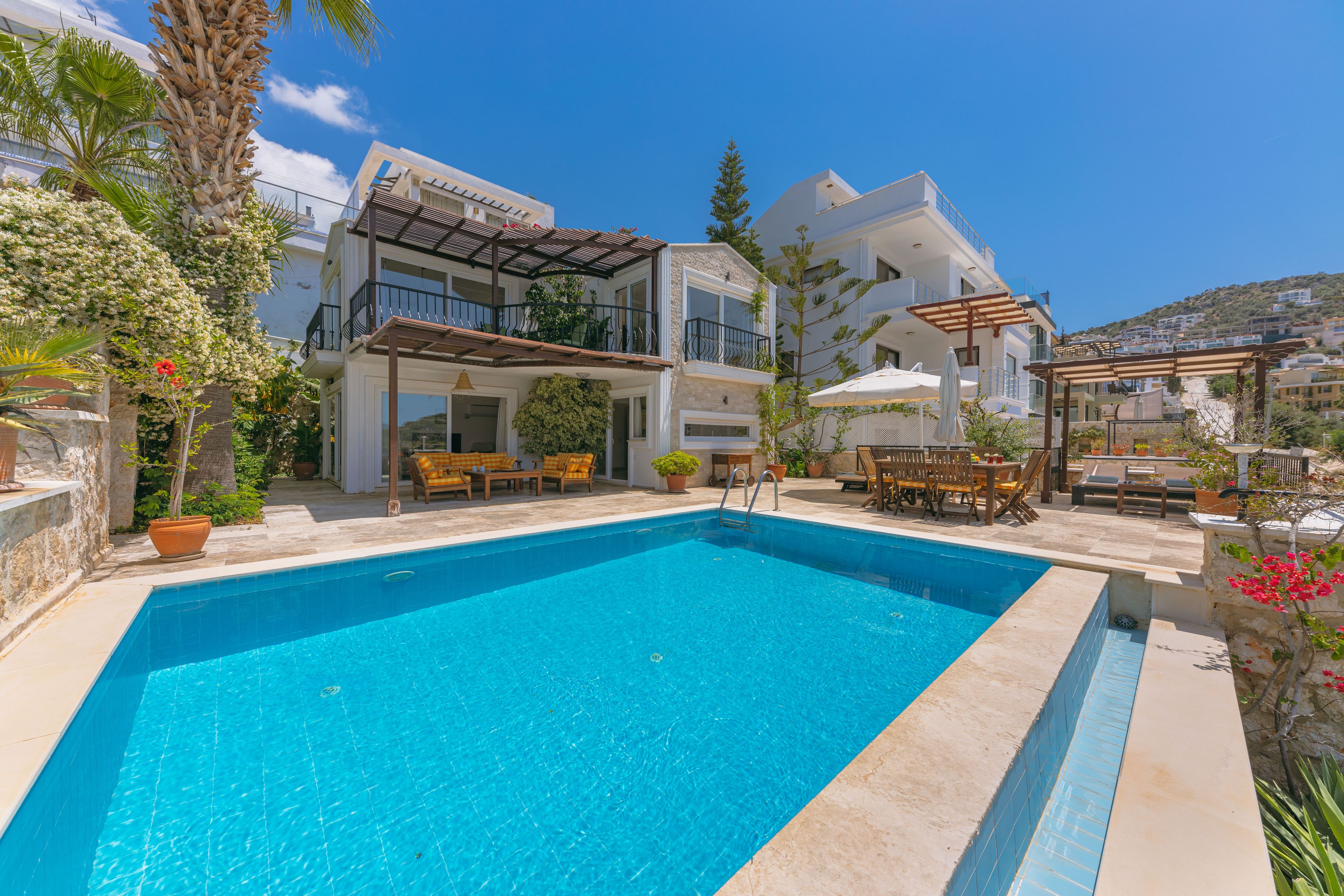 Luxury villa with a blue swimming pool and sunlit terrace